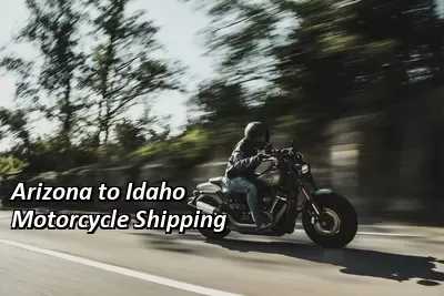 Rider on a silver cruiser motorcycle riding past green hills, Arizona to Idaho motorcycle shipping