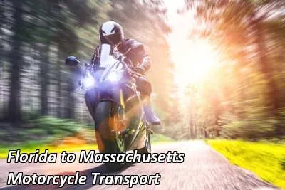 Rider on a silver cruiser motorcycle riding past green hills, Florida to Massachusetts motorcycle shipping